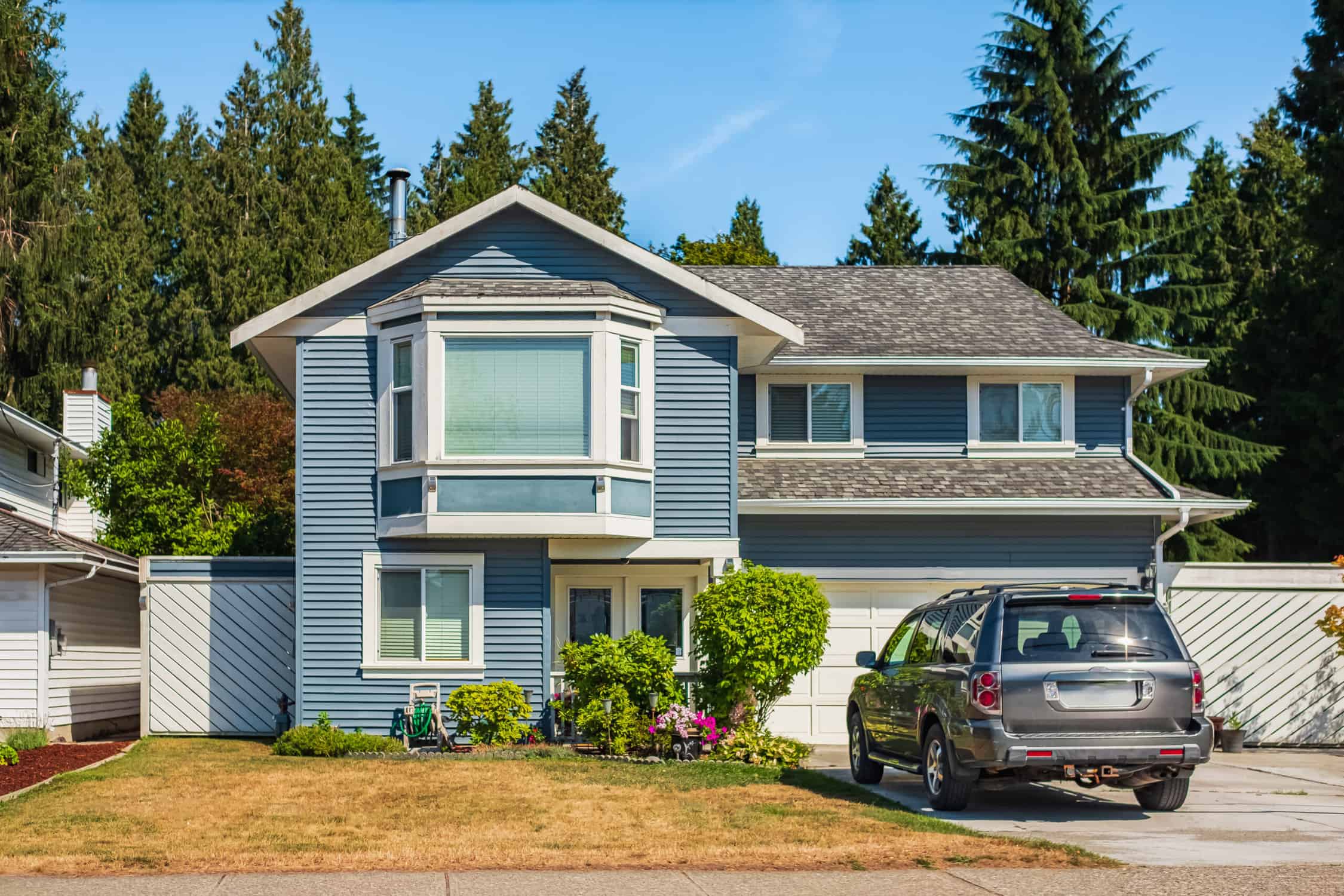 Contemporary house exterior in Vancouver Canada. Big modern house with beautiful landscaping and driveway to garage. Front view of modern designed residential house. North American Home in the suburbs